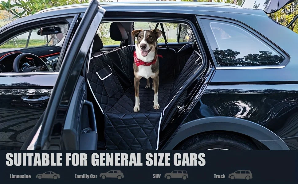 A dog is sitting in the backseat of a car, which has a black waterproof seat cover installed.