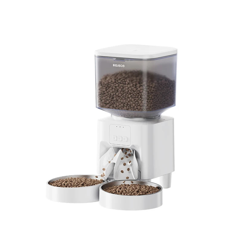 A white smart automatic pet feeder with a clear top, dispensing brown pet food into a bowl.