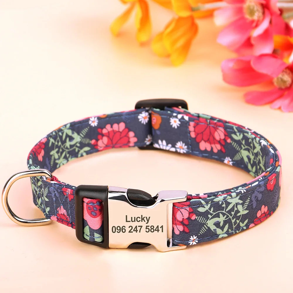 A dark blue floral print dog collar with a silver buckle and an engraved name tag reading Lucky 096 247 5841.