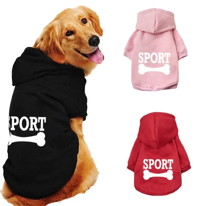 A dog wearing a black fleece hoodie with white bone print, alongside pink and red sport hoodies.