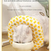 A fluffy white cat is comfortably resting inside a yellow patterned soft cotton recovery collar for dogs and cats.