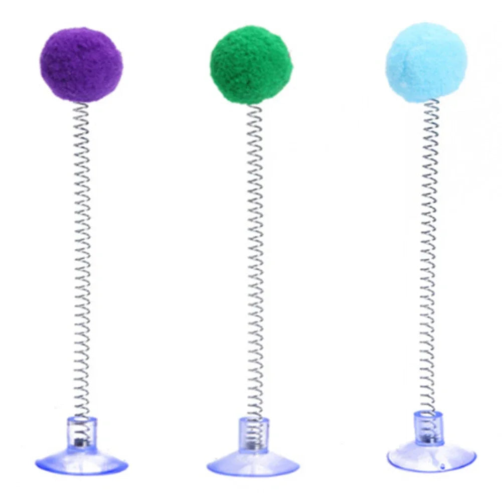 Three colorful spring cat toys with felt balls on metal rods and suction cup bases