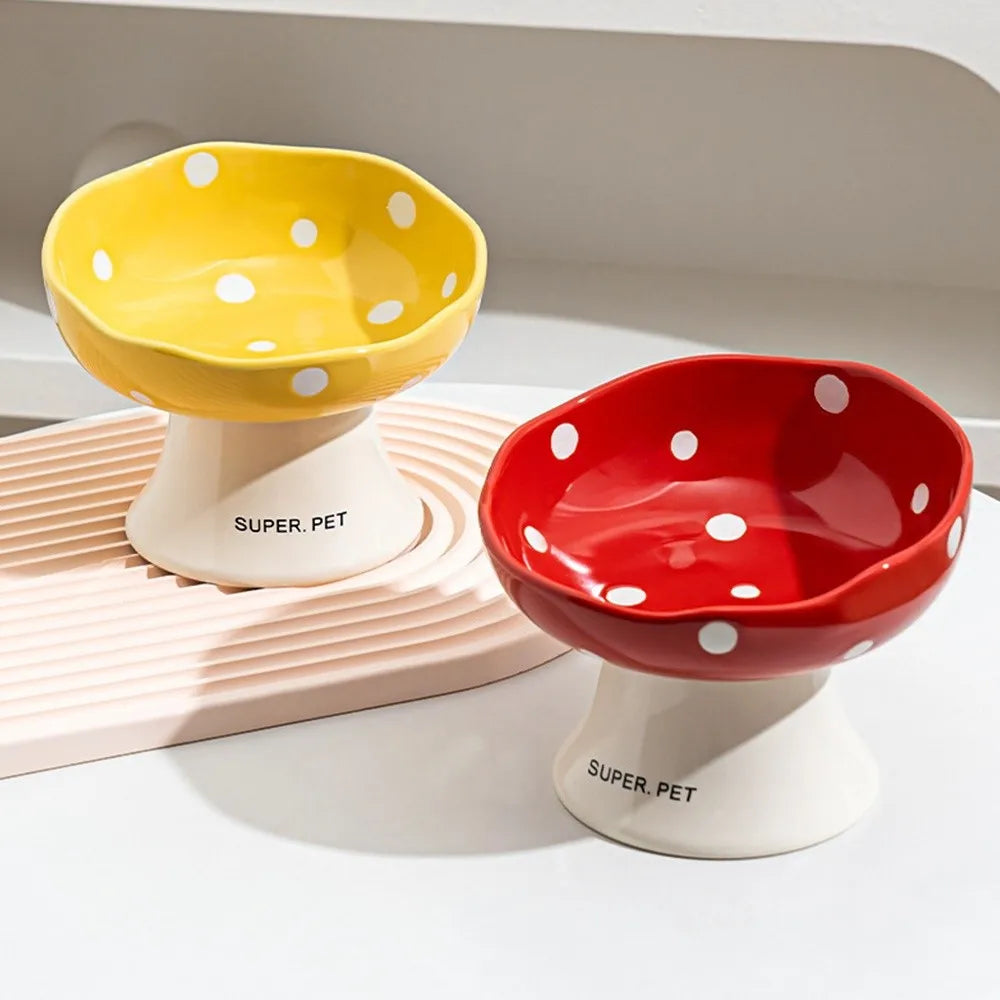 Two ceramic pet bowls, one yellow and one red, with white polka dots, displayed on a white surface.