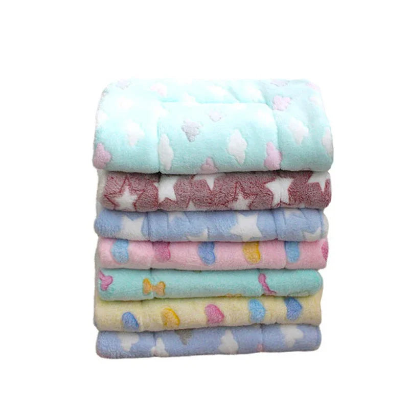 A stack of colorful plush fleece pet blankets and mats for dogs and cats.