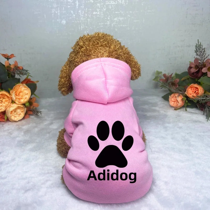 Pink Adidog hoodie sweatshirt with a brown dog head attached, displayed on a white surface.