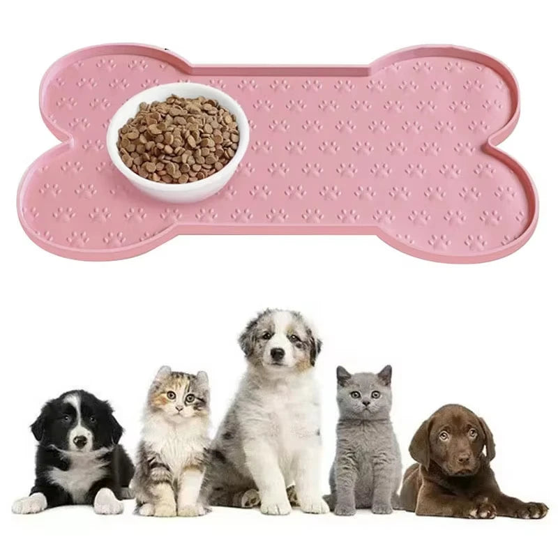 A pink silicone pet feeding mat with a raised edge is shown alongside several cats and a dog.