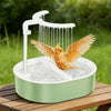 A white USB electric bird bath with a water pump is shown pouring water over a bird in an outdoor setting.