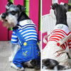 A dog wearing a blue and white striped seaman costume jumpsuit with yellow accents.