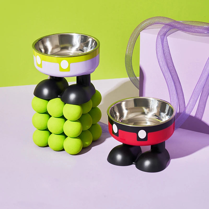 A set of colorful pet bowls featuring stainless steel bowls and rubber-like colored accents on a light purple surface.