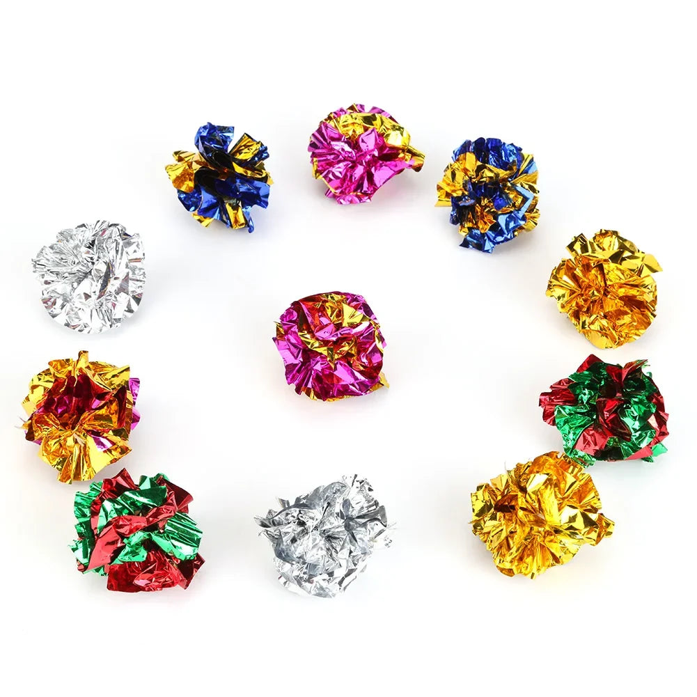 A circular arrangement of colorful crinkle balls, including purple, pink, blue, and gold, used as cat toys.