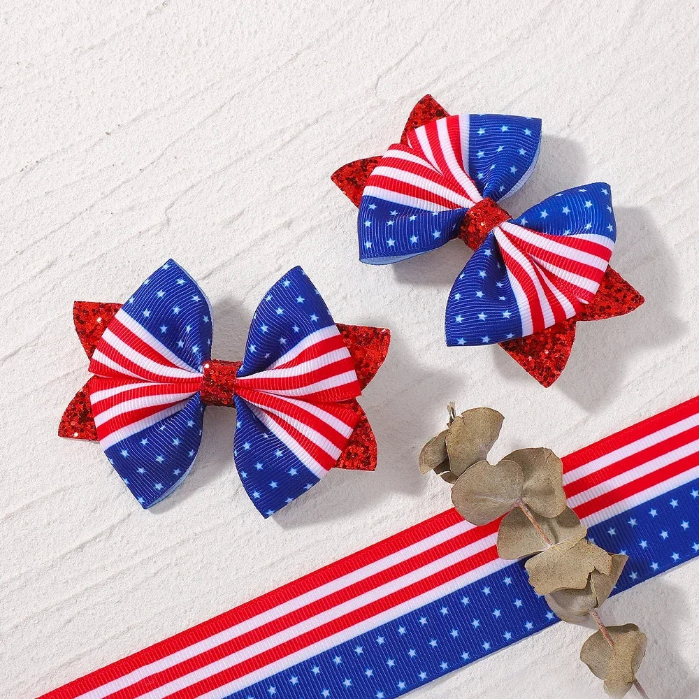 A pair of red, white, and blue striped ribbon hair bows with clips are displayed on a white background.
