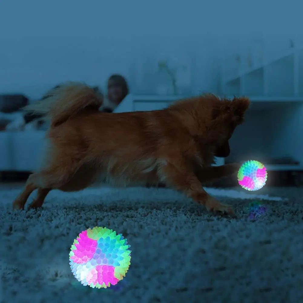 A brown dog is running across a light surface with glowing, colorful fetch balls on the ground.