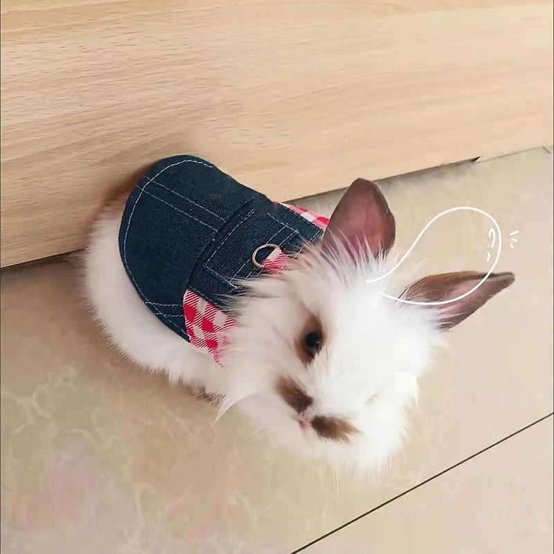 Un lapin blanc portant un costume de lapin en denim avec des accents à carreaux rouges, allongé sur une surface en bois clair