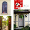 A window with a red alert sticker and a decorative iron gate next to a house entrance.