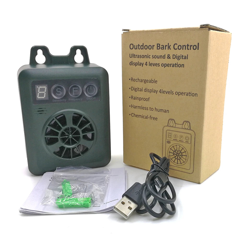 Un dispositif anti-aboiement ultrasonique gris pour chien et ses accessoires, à côté de sa boîte d'emballage.