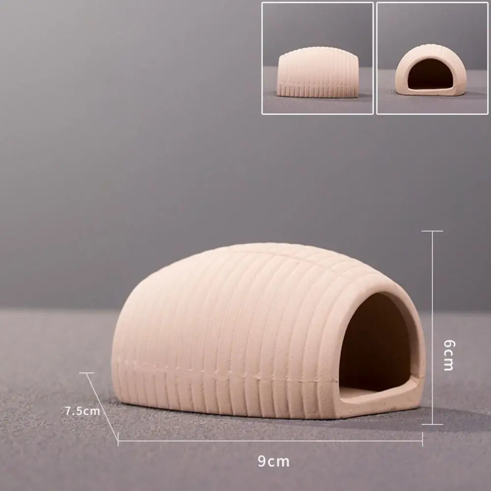 A beige ceramic aquarium shrimp hideaway cave with a rounded, ribbed exterior and an arched entrance.