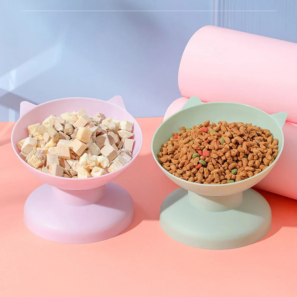 Pink and mint green elevated bowls filled with dry pet food for cats and dogs