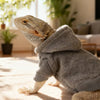A bearded dragon costume resembling a lizard is shown resting on a light-colored surface.