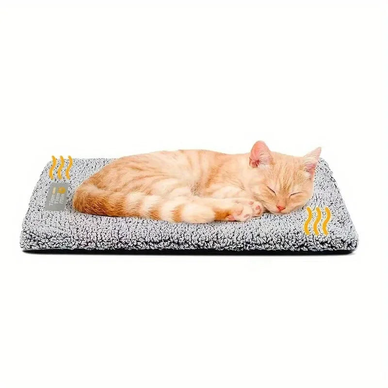 An orange tabby cat is lying on a gray, textured pet bed mat.