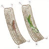 A woven natural fiber reptile hammock lounger with a green lizard inside.