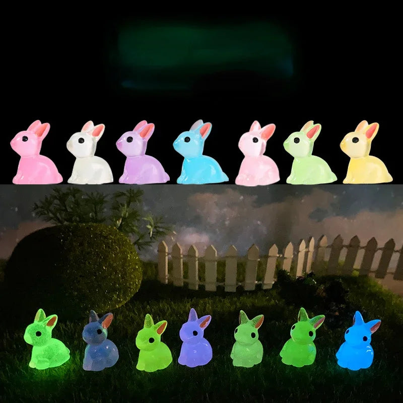 A set of glow-in-the-dark resin bunny figurines in various pastel colors arranged on a grassy surface.