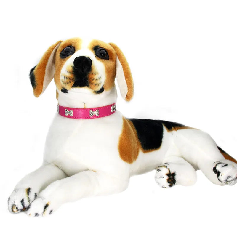 A white and tan dog plush toy with floppy ears wearing a pink leather collar.