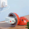 An orange interactive self-moving pet ball is shown next to a white charging base on a wooden surface.