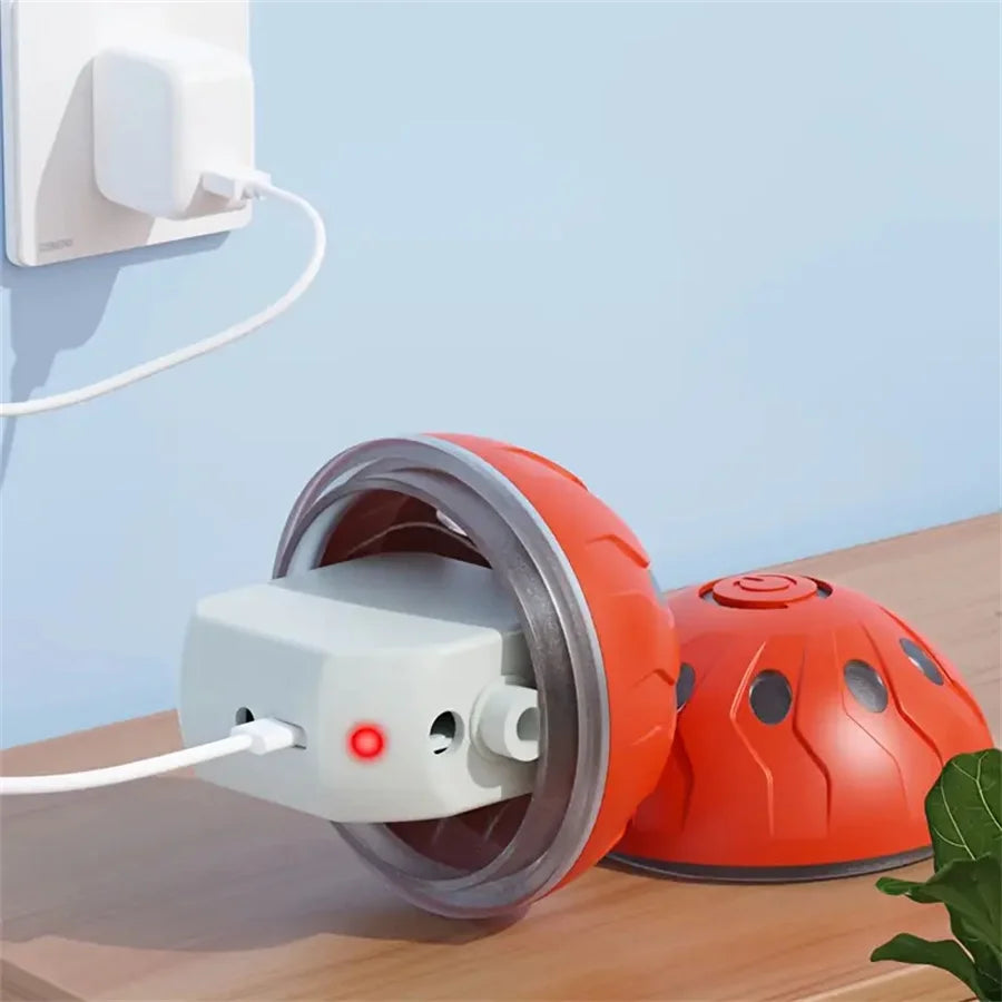 An orange interactive self-moving pet ball is shown next to a white charging base on a wooden surface.