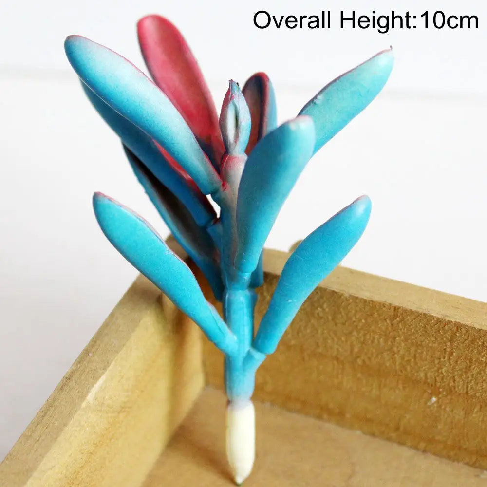 A small blue artificial succulent plant with pink and red leaves is displayed in a wooden box.