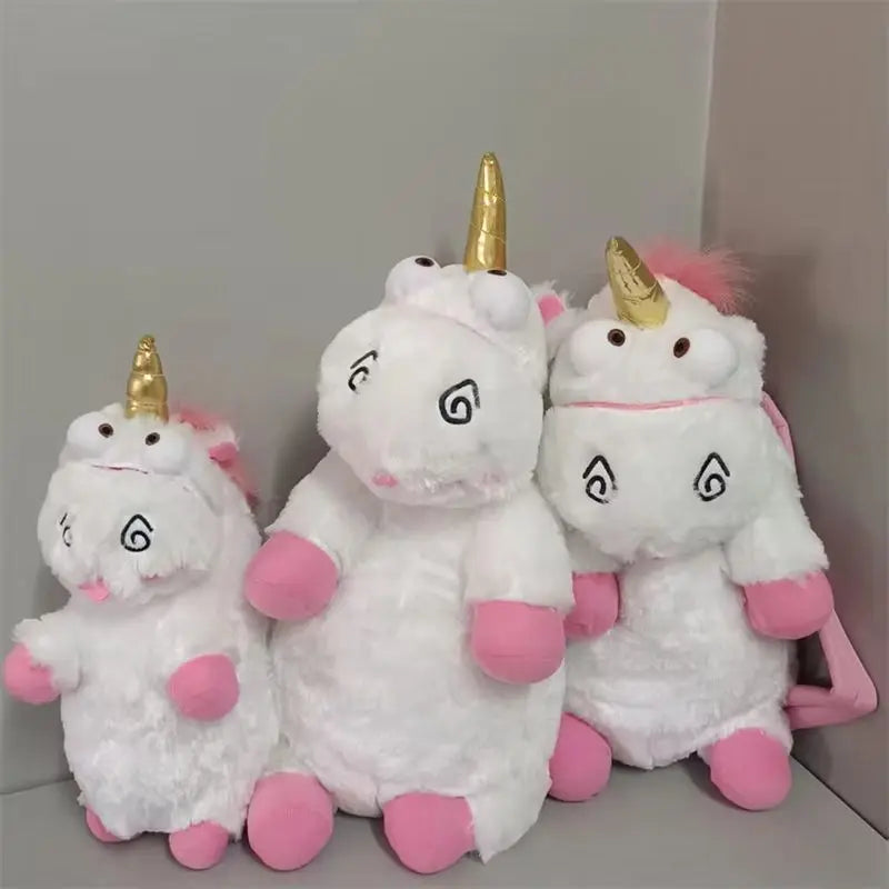 Three white unicorn plush dolls with gold horns and pink accents sitting together.