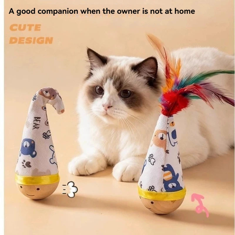 A fluffy white and gray cat is sitting next to two cone-shaped feather toys for indoor play.
