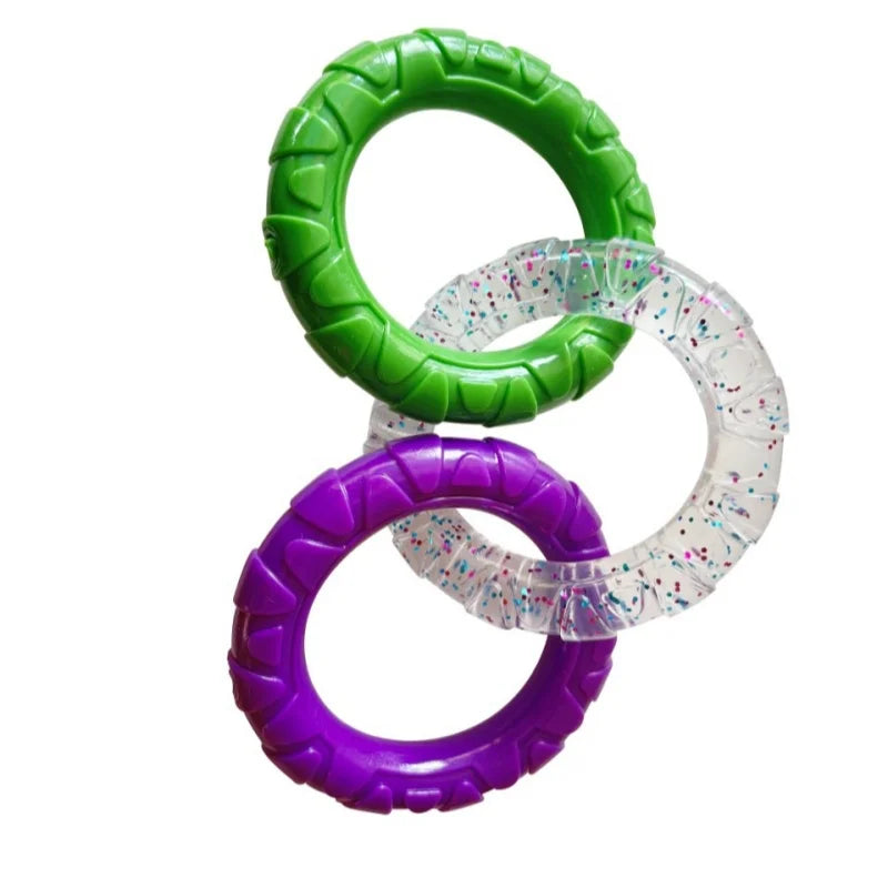 Three rings of TPR pull toy for dogs, colored green, purple, and clear with glitter.