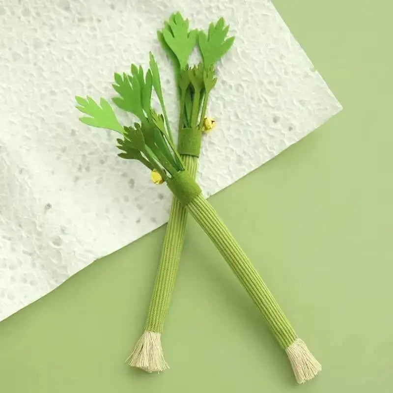 Green celery stalks with leaves tied together and a bell, resting on a white cloth.