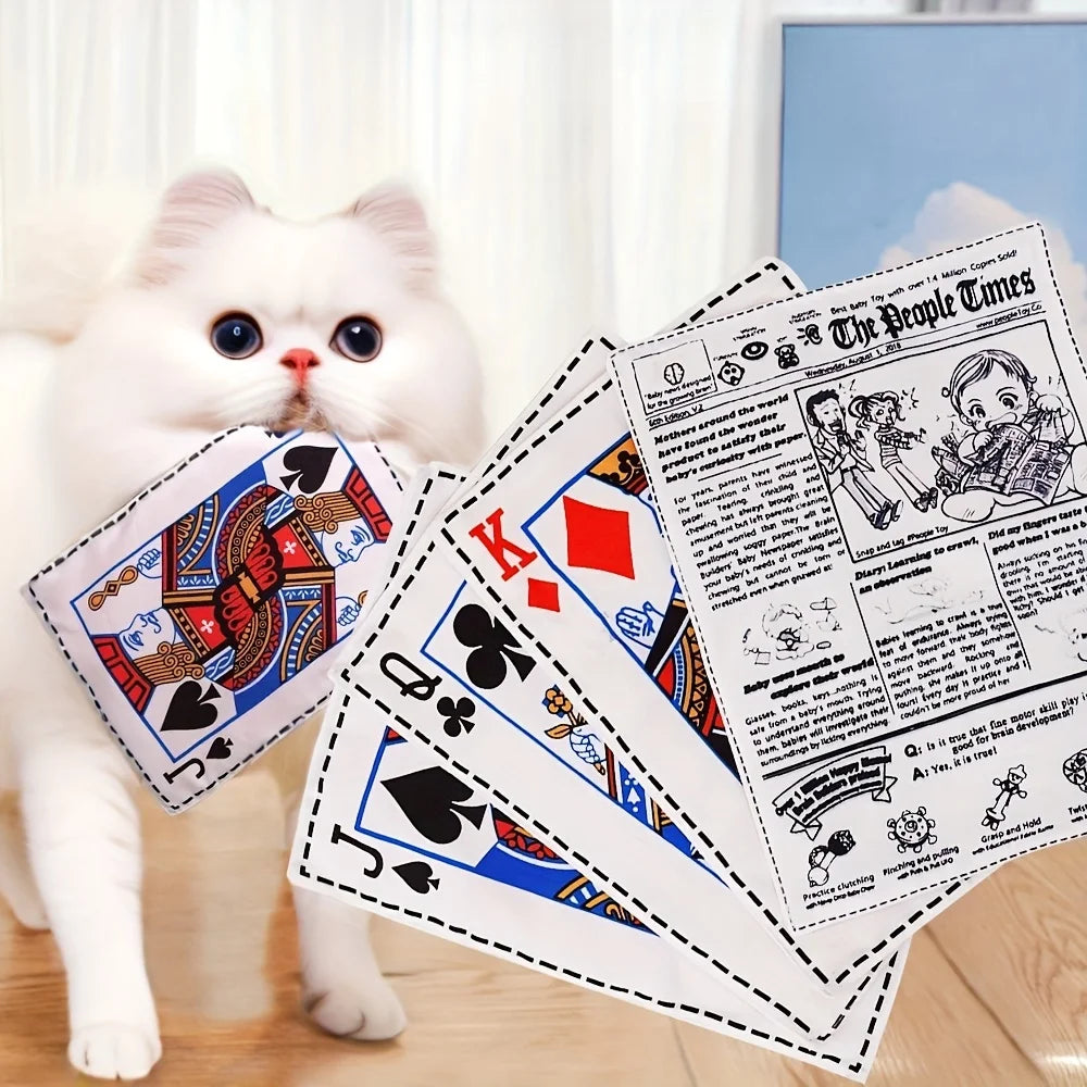 A white cat is playing with a newspaper design squeaky plush dog toy featuring The People Times headlines.