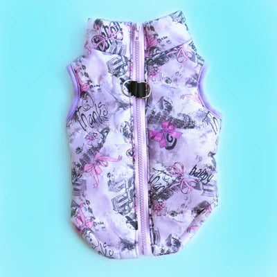 A purple and pink patterned cozy winter dog coat with a zipper is displayed against a light blue background.
