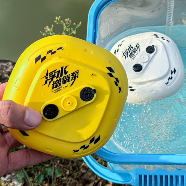 A hand holds a yellow floating USB rechargeable pond aerator pump inside a blue container.