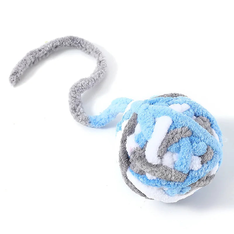 A soft plush cat toy ball featuring gray and blue textured fur with a curved tail.