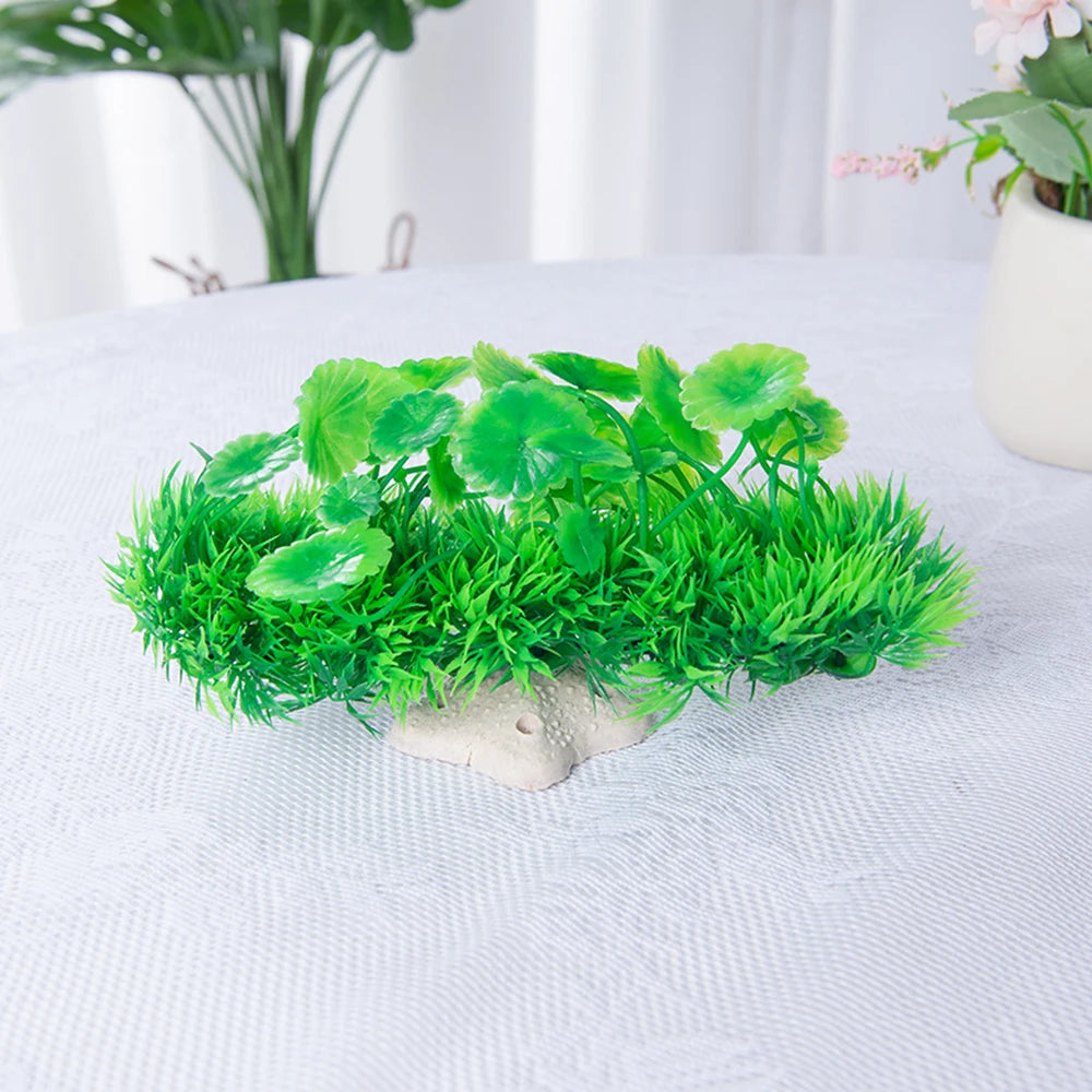 Planta acuática artificial con follaje verde brillante creciendo de una base de cerámica clara.