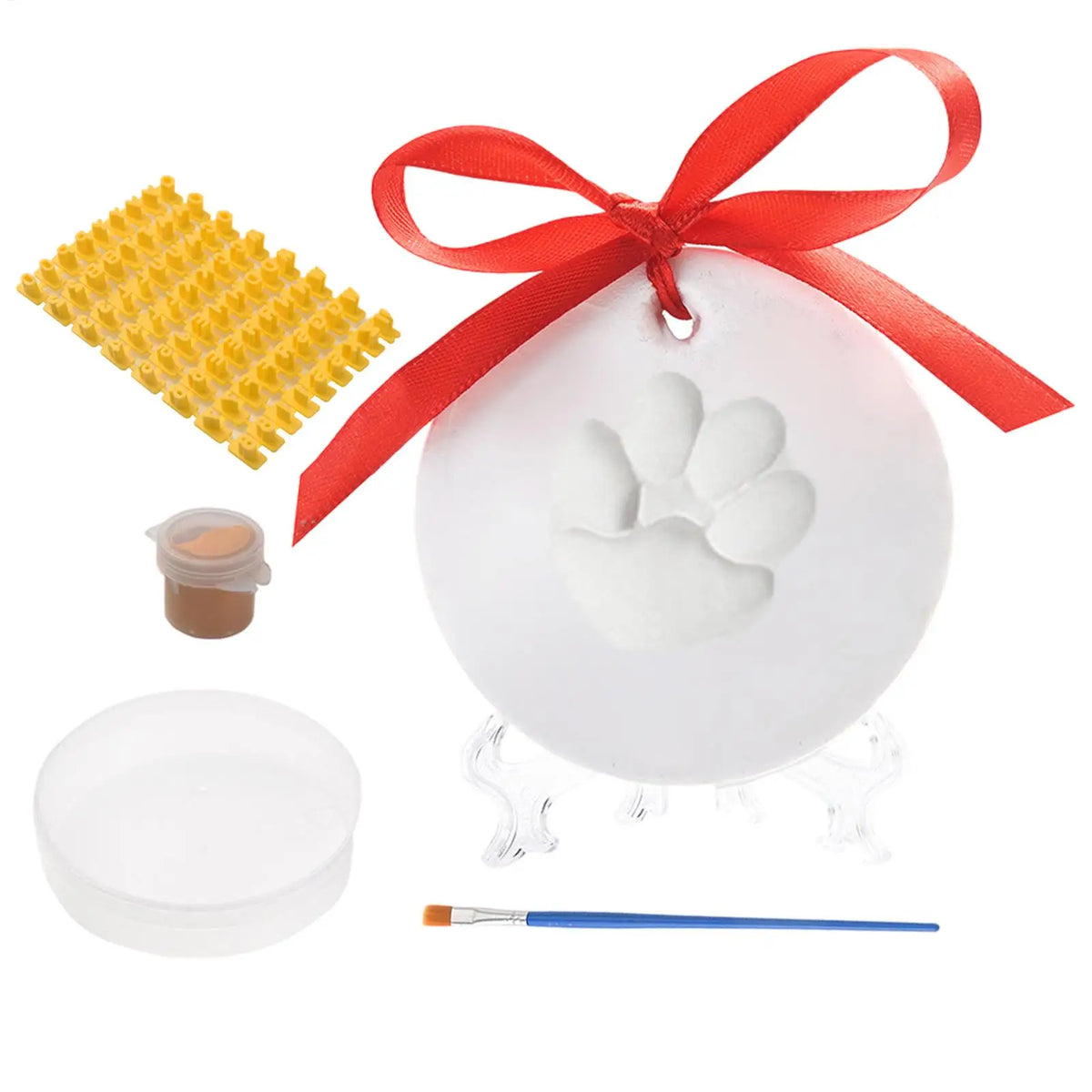 Set mit weißer Pfotenspur-Imprägnierung: Silikonmatte, rotes Band und kleiner Pinsel.