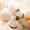 A white fluffy pet vest with a cartoon print featuring small dogs and brown accents.