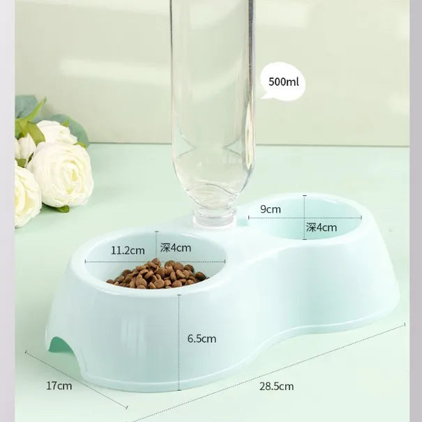 A white dual-bowl feeder for pets, featuring a food compartment and water dispenser, shown next to a glass.