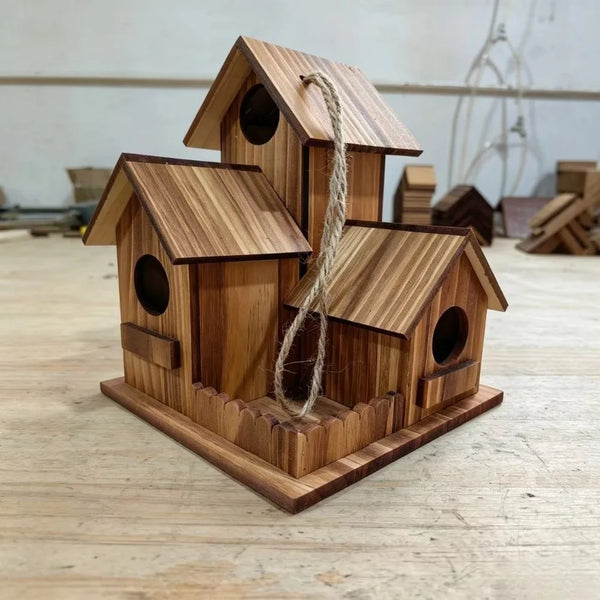 Nid d'oiseau rustique en bois clair avec toit incliné et ficelle naturelle à l'entrée.