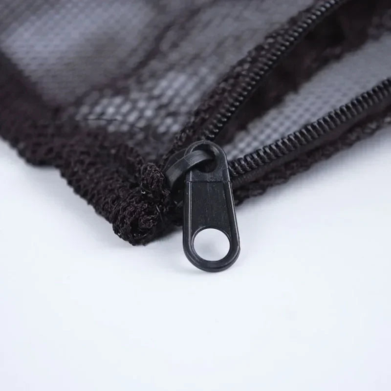 Close-up of a black mesh bag with a zipper and a metal clip, used for aquarium filter media.