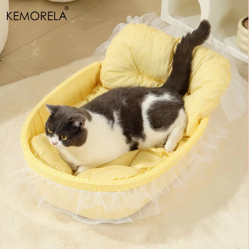 A black and white cat is lying in a yellow gauze-trimmed pet bed mat.