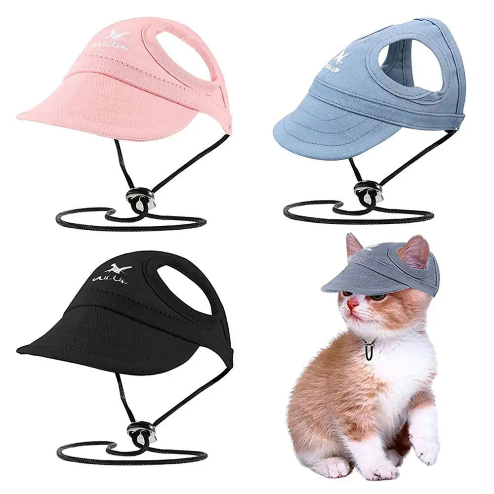Vier verstellbare Hundebälle-Hüte in rosa, blau, schwarz und grau, wobei eine Katze den grauen Hut trägt.