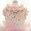 Pink floral vest for dogs and cats displayed on a mannequin with ruffled trim