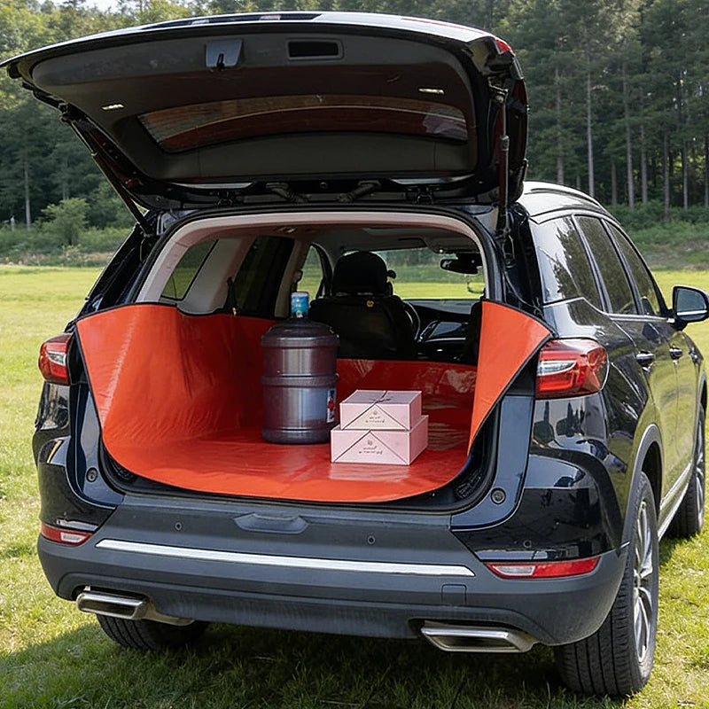 A black SUV's trunk is open, showing a bright orange waterproof mat designed as a pet barrier.