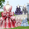 A plaid dress for a dog featuring red and pink patterns in various plaid fabrics.