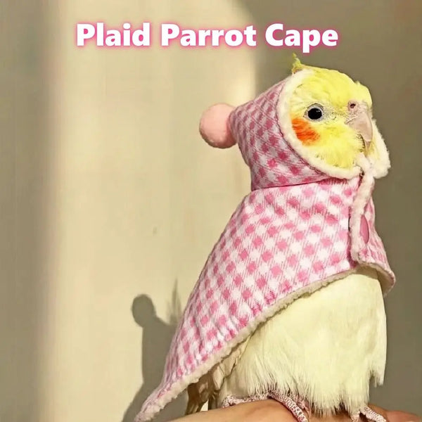 A parrot wearing a pink plaid cape and matching hat, showing its fluffy white feathers.