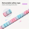 Close-up view of a pink and blue retractable safety rope with elastic cushioning.